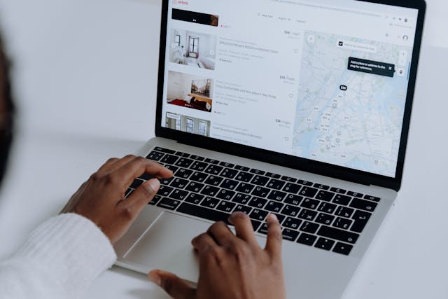 Person using a laptop to view property listings